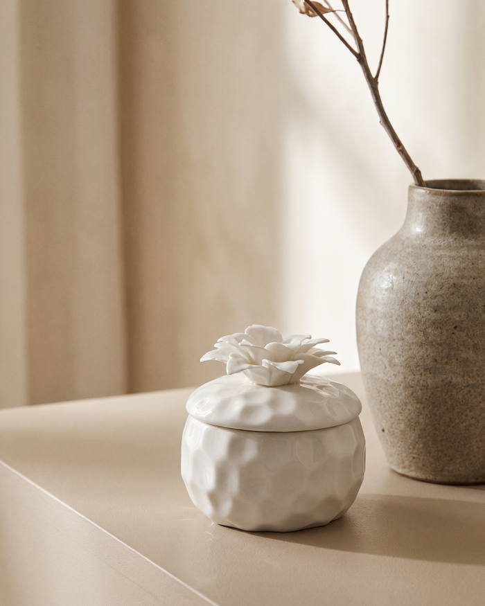 The Bloom pomegranate and pink pepper soy candle in its ceramic vessel with a bamboo lid