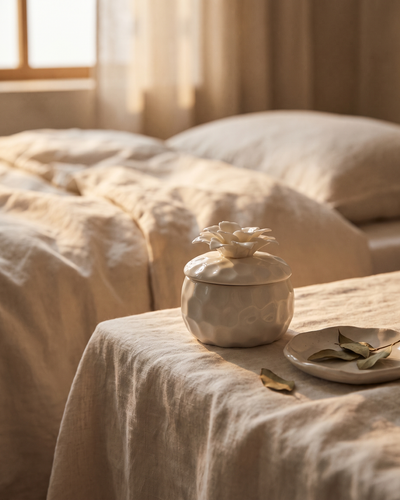The Bloom soy candle in its ceramic vessel with the bamboo lid resting beside it