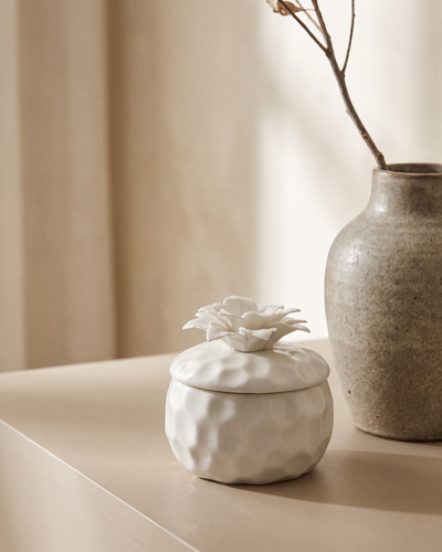 The Bloom pomegranate and pink pepper soy candle in its ceramic vessel with a bamboo lid