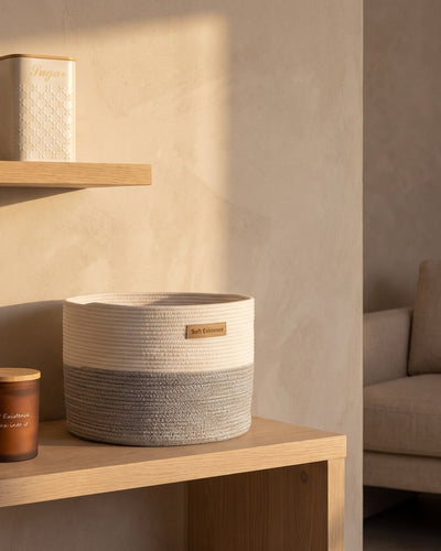 Calm Dubai apartment corner with a frosted amber soy candle, woven cotton basket and cream canister in warm light